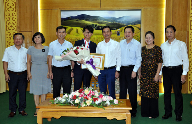 Đồng chí Dương Văn Tiến - Phó Chủ tịch UBND tỉnh và các đồng chí lãnh đạo Sở Giáo dục và Đào tạo trao bằng khen và phần thưởng cho em Nguyễn Đình Hoàng giành Huy chương Bạc, trong Kỳ thi Olympic Hóa Học năm 2019.