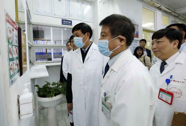 Thứ trưởng Đỗ Xuân Tuyên (trái) cùng đoàn công tác của Bộ Y tế kiểm tra công tác trực Tết và tặng quà cho một số bệnh nhân nặng điều trị tại bệnh viện Bệnh Nhiệt đới Trung ương.