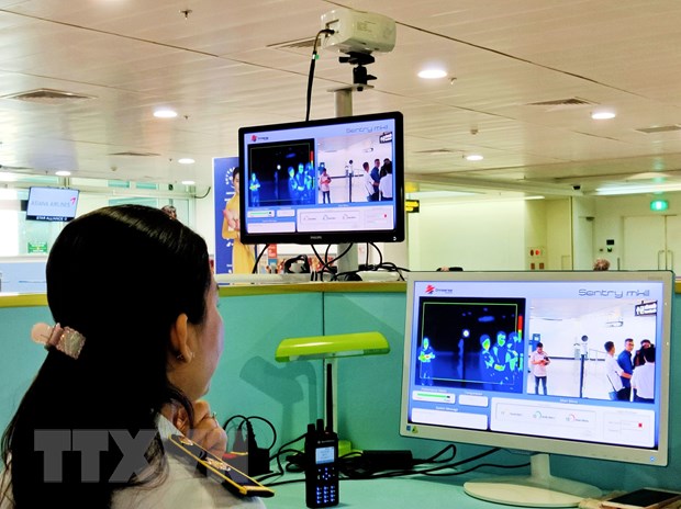 Nhân viên sân bay Tân Sơn Nhất theo dõi trên màn hình hiển thị máy quét thân nhiệt đối với hành khách quốc tế đến Việt Nam.