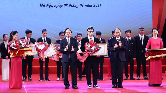 Thủ tướng Nguyễn Xuân Phúc và Bộ trưởng Bộ GD-ĐT Phùng Xuân Nhạ trao thưởng cho các em học sinh.