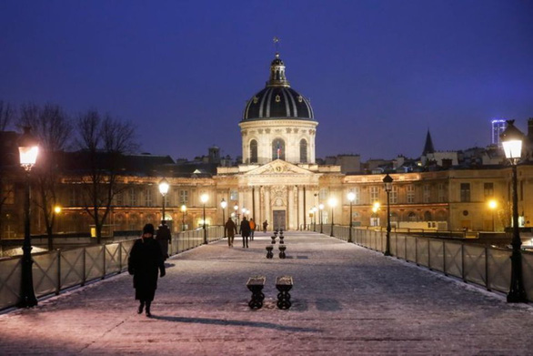 Người dân đi bộ ở Paris trong những ngày Pháp đẩy lệnh giới nghiêm lên sớm hai tiếng so với trước đó, từ 18h cho tới 6h sáng hôm sau mỗi ngày