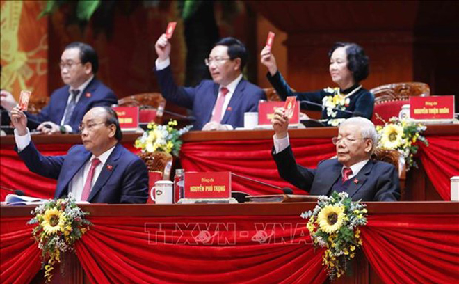 Party General Secretary and State President Nguyen Phu Trong and other members of the Presidium vote to adopt the agenda of the 13th National Party Congress.