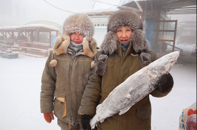 Hai phụ nữ bán cá Marina Krivolutskaya và Marianna Ugai đứng chụp ảnh ở khu chợ ngoài trời tại Yakutsk.