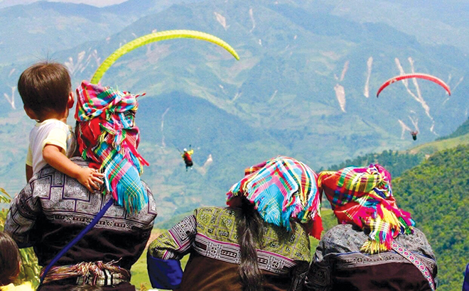 Người dân thích thú ngắm dù lượn tại Festival Dù lượn “Bay trên mùa vàng” tại điểm bay dù lượn đèo Khau Phạ, huyện Mù Cang Chải.