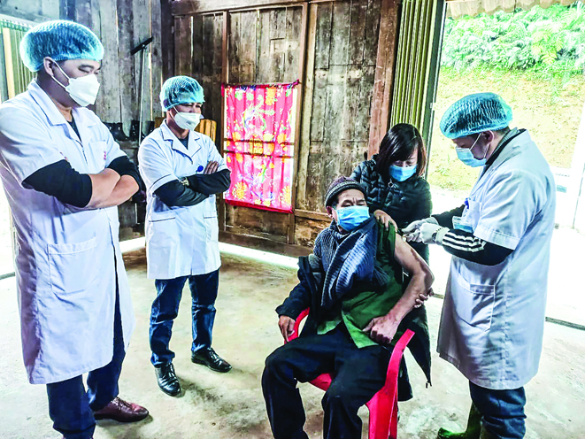 Các y bác sĩ ở tỉnh Yên Bái phải vượt rừng, lội suối đến tận nhà tiêm vaccine cho người dân.