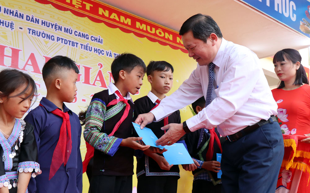 Đồng chí Vương Văn Bằng - Giám đốc Sở Giáo dục và Đào tạo tỉnh tặng quà cho học sinh Trường Phổ thông dân tộc bán trú TH và THCS Hồ Bốn, huyện Mù Cang Chải trong ngày khai giảng năm học mới 2023 - 2024.