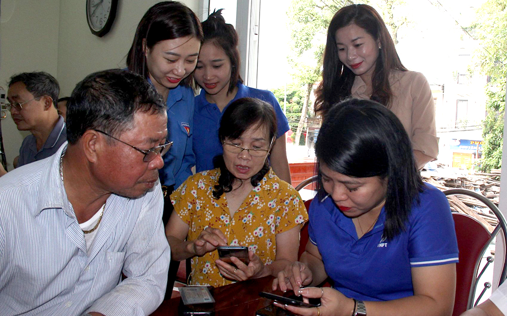 Đoàn viên thanh niên phường Minh Tân, thành phố Yên Bái hướng dẫn người dân cài đặt các ứng dụng số trên thiết bị điện thoại thông minh.