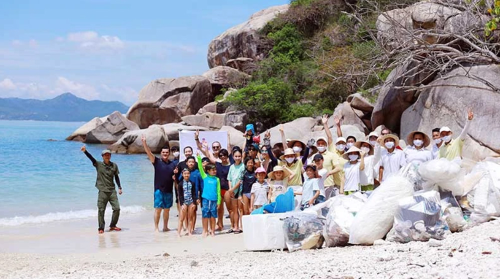 Du khách tham gia hoạt động nhặt rác trên bãi biển do khu nghỉ dưỡng Six Senses Ninh Van Bay tổ chức.