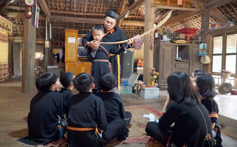 Nghệ nhân Hoàng Hữu Định truyền dạy phương pháp thổi kèn nứa gắn với văn hóa dân tộc Dao cho các em học sinh Trường THCS xã Yên Thành.