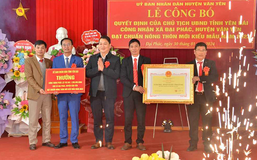 Thừa ủy quyền, lãnh đạo UBND huyện Văn Yên trao Quyết định của Chủ tịch UBND tỉnh công nhận xã Đại Phác đạt chuẩn NTM kiểu mẫu năm 2023 và tặng biểu trưng công trình phúc lợi của UBND tỉnh cho xã.