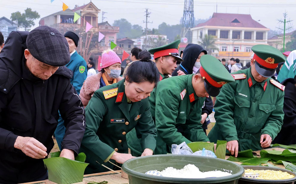 Người dân và các cán bộ chiến sĩ tham gia gói bánh chưng trong Chương trình.
