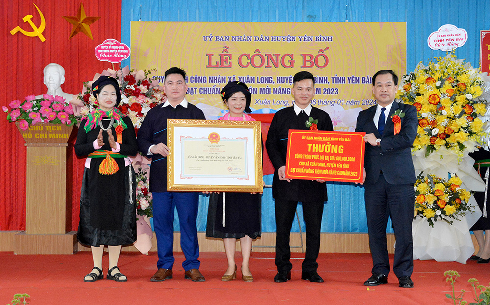 Lãnh đạo UBND huyện Yên Bình trao quyết định và tặng công trình phúc lợi của UBND tỉnh Yên Bái cho Đảng bộ, chính quyền, nhân dân xã Xuân Long.