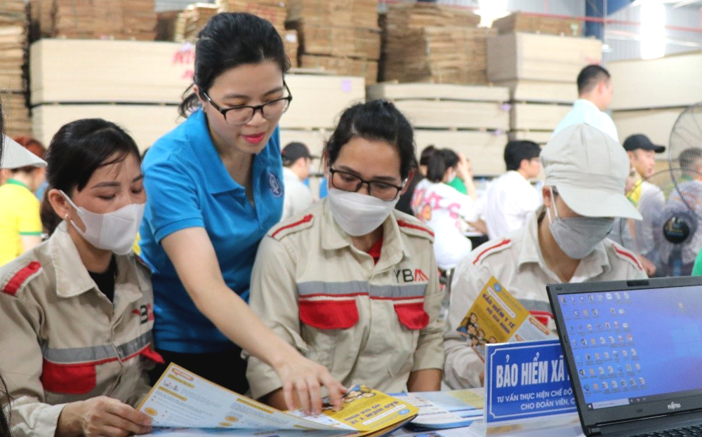 Viên chức Bảo hiểm Xã hội tỉnh tuyên truyền chính sách đến người lao động.