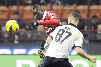 Tiền đạo Mario Balotelli (trái, AC Milan) tung cú dứt điểm trước hậu vệ Parma Aleandro Rosi.