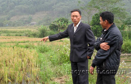 Bí thư Chi bộ thôn Bản Hốc - Lò Xuân Liên (người bên phải) trao đổi với lãnh đạo xã Đồng Khê về hiệu quả của việc chuyển đổi mô hình trồng ngô sang nuôi cá ruộng của thôn.
