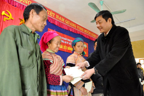 Lãnh đạo đại diện Văn phòng Báo Công an thành phố Hồ Chí Minh trao quà cho các hộ nghèo xã Nà Hẩu (Văn Yên).