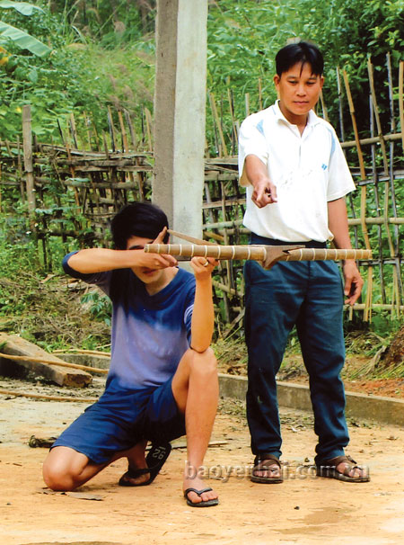 Anh Tăng Văn Thủy dạy con trai các yếu lĩnh bắn nỏ.
