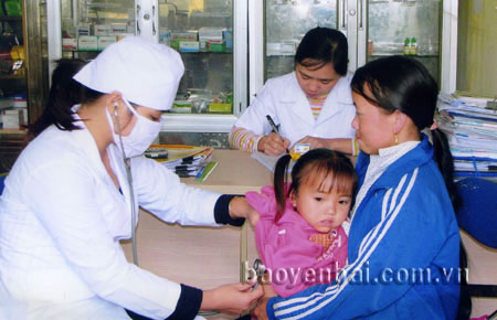 Cán bộ y tế xã Bản Công khám sức khỏe cho trẻ em.
