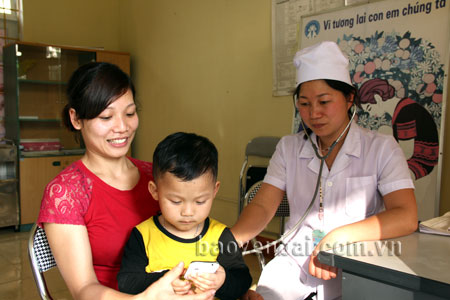 Bác sỹ Phạm Thị Thủy thăm khám bệnh cho trẻ em tại Trạm Y tế xã.
