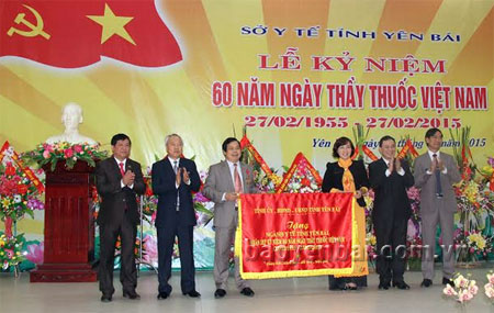 Chủ tịch UBND tỉnh Phạm Duy Cường  trao bức cờ thêu của Tỉnh ủy, HĐND, UBND tỉnh cho lãnh đạo ngành Y tế Yên Bái.