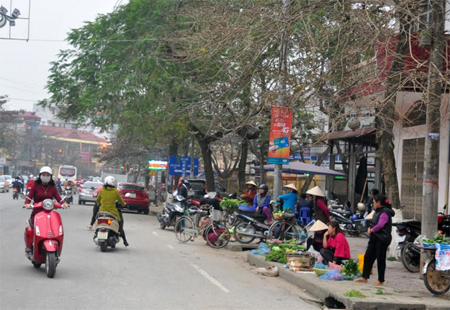 Tình trạng vi phạm hành lang an toàn giao thông còn diễn ra phổ biến tại khu vực chợ Đồng Tâm.