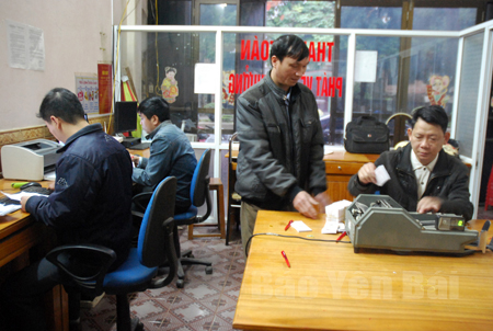 Anh Hoàng Thế Vĩnh (đứng bên trái) nộp bảng kê và cuống vé tại Văn phòng Xổ số Nguyễn Thái Học.