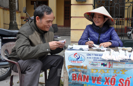 Khách hàng tham gia mua vé xổ số tại một đại lý bán vé số lẻ ở thị trấn Yên Bình.

