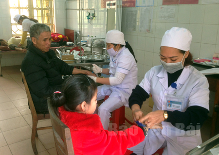 Các y, bác sỹ Trung tâm Y tế huyện Yên Bình khám, chữa bệnh cho người dân.