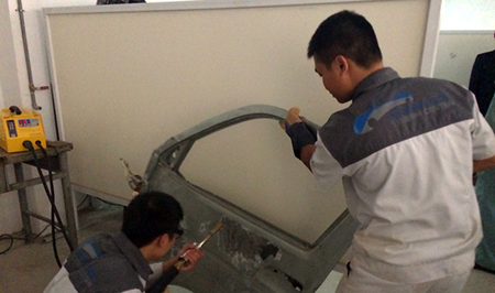 Học viên Trường Cao đẳng nghề Công nghiệp Hà Nội đang thực hành nghề sơn sửa vỏ ô tô.