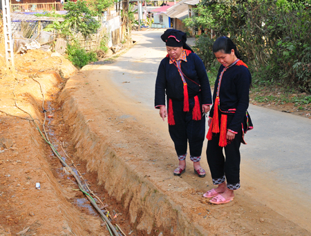 Chị Lý Thị Pham (bên trái) trao đổi với chị em thôn Giàng Cài vệ sinh đoạn đường tự quản và công tác vệ sinh môi trường.