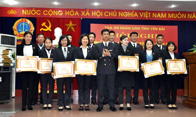 Thừa ủy quyền, Chánh án TAND tỉnh Phan Văn Tiến (giữa) trao bằng khen của Chánh án TAND Tối cao cho các tập thể và cá nhân có thành tích xuất sắc năm 2018.