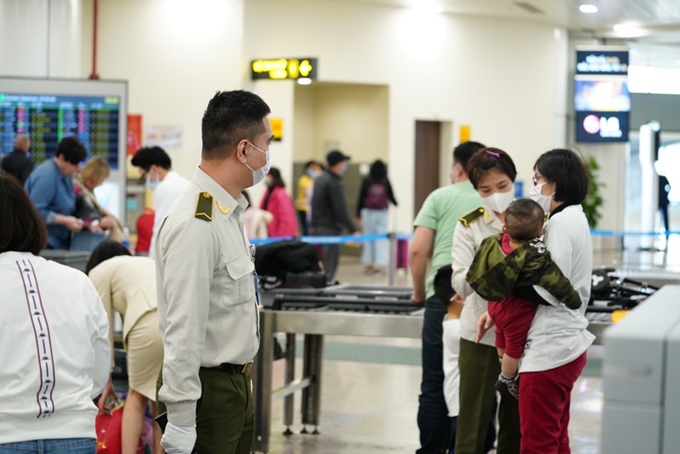 Các hành khách đeo khẩu trang tại sân bay Nội Bài.
