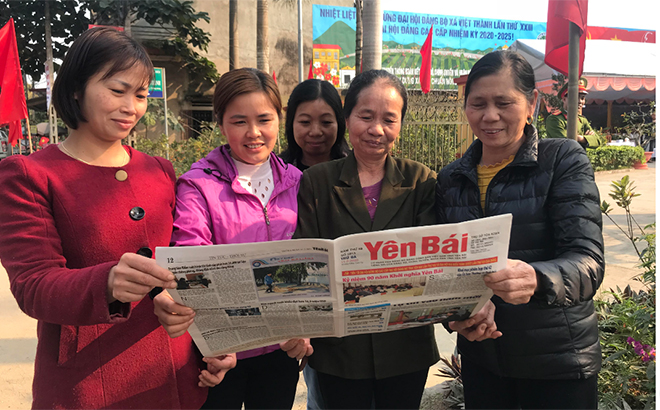 Nhân dân xã Việt Thành phấn khởi theo dõi tin tức về Đại hội trên báo Đảng. (Ảnh: Hồng Oanh)