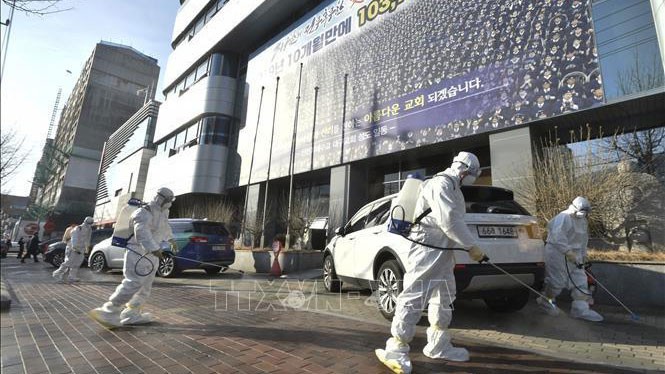 Nhân viên y tế phun thuốc khử trùng phía trước một nhà thờ của giáo phái Shincheonji ở Daegu, Hàn Quốc, nhằm ngăn chặn sự lây lan của Covid-19, ngày 19/2/2020.