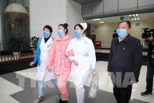 Bệnh nhân nhiễm COVID-19 (thứ 2, trái) xuất viện sau khi được chữa khỏi tại bệnh viện ở tỉnh Quý Châu, Trung Quốc, ngày 8/2/2020.
