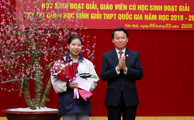 Chairman of the provincial People’s Committee Do Duc Duy presents a reward to Bui Thi Nhung, a 12th grader of the Nguyen Tat Thanh High School for the Gifted, who earned a score of 17 out of 20 points to win the first prize at the national contest on geography for the 2019-2020 academic year.