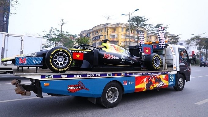 The F1 model car is carried on a truck during the parade in Hanoi on February 22.