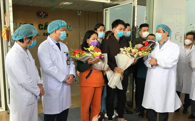 Phó giáo sư Lương Ngọc Khuê (bên phải) chúc mừng hai bệnh nhân nhiễm Covid-19 xuất viện chiều 18-2