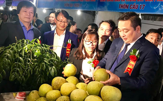 Đồng chí Đoàn Hữu Phung - Bí thư Huyện ủy Yên Bình (thứ nhất, bên phải) thăm gian hàng giới thiệu sản phẩm bưởi tại xã Đại Minh.