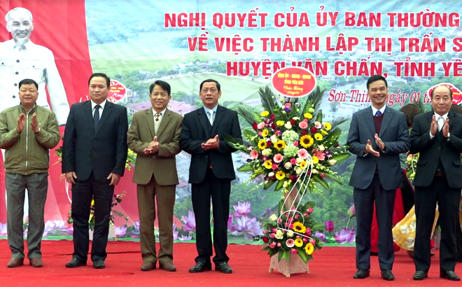 Duong Van Tien, Vice Chairman of the provincial People's Committee, presents flowers to congratulate the Party Organisation, authorities and people of Son Thinh township.