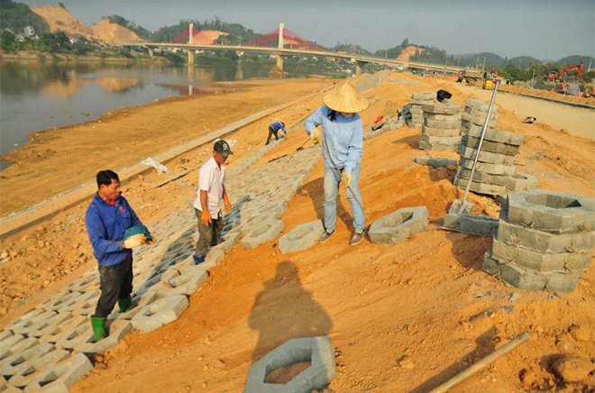 Công nhân liên danh nhà thầu Lâm Việt - Bình Dương đẩy nhanh tiến độ thi công công trình đê chống ngập sông Hồng.