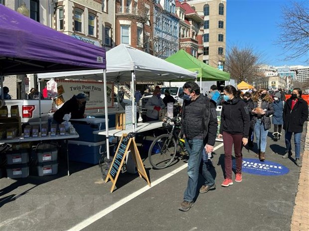 Người dân đeo khẩu trang phòng lây nhiễm COVID-19 tại một khu chợ ở Washington, DC, Mỹ, ngày 21/2/2021.