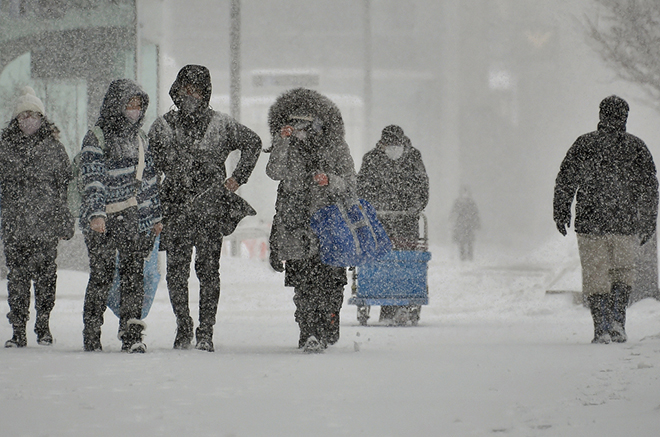 Người dân Sapporo, Hokkaido, Nhật Bản đi bộ dưới tuyết ngày 26/1.