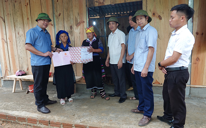Các đồng chí lãnh đạo huyện Mù Cang Chải trao sổ đỏ và nhà ở cho hộ gia đình bà Giàng Thị Chù thuộc diện hộ nghèo đặc biệt khó khăn ở xã La Pán Tẩn.