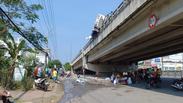 Xe tải chở cá lật ngang trên cầu, nhiều tấn cá văng ra cả ở trên và dưới gầm cầu.