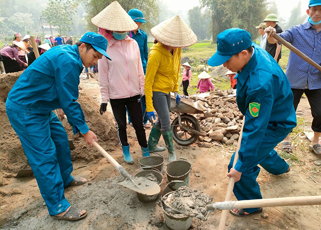 Dân quân huyện Văn Chấn giúp dân tu sửa đường giao thông nông thôn.