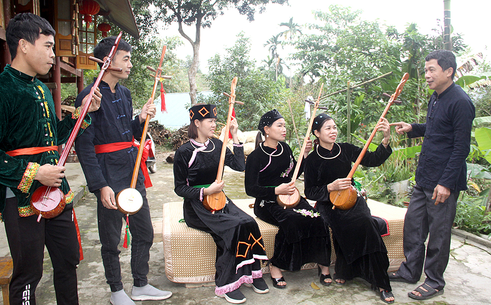 Nghệ nhân Hà Văn Nguyện hướng dẫn học viên hát then, đàn tính.