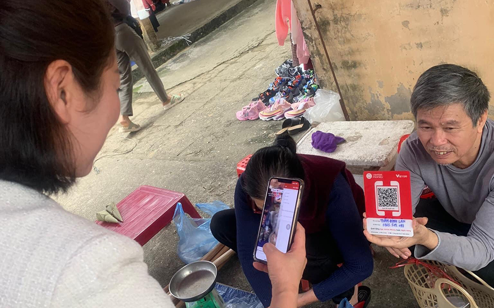Người dân thôn Phố Hóp, xã Báo Đáp sử dụng ứng dụng thanh toán không dùng tiền mặt khi mua bán.