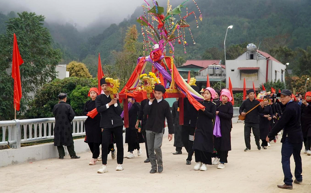 Các chàng trai, cô gái trong trang phục truyền thống rước mâm cỗ, dâng cỗ từ Đình Chạng đến khu vực tế lễ tại sân vận động trung tâm xã Phong Dụ Thượng.