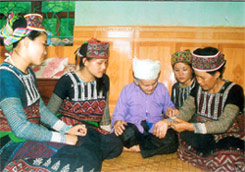 Cụ Bơ Thị Ma đang truyền dạy con, cháu thêu hoa văn trên váy, áo truyền thống của người Xa Phó.  
